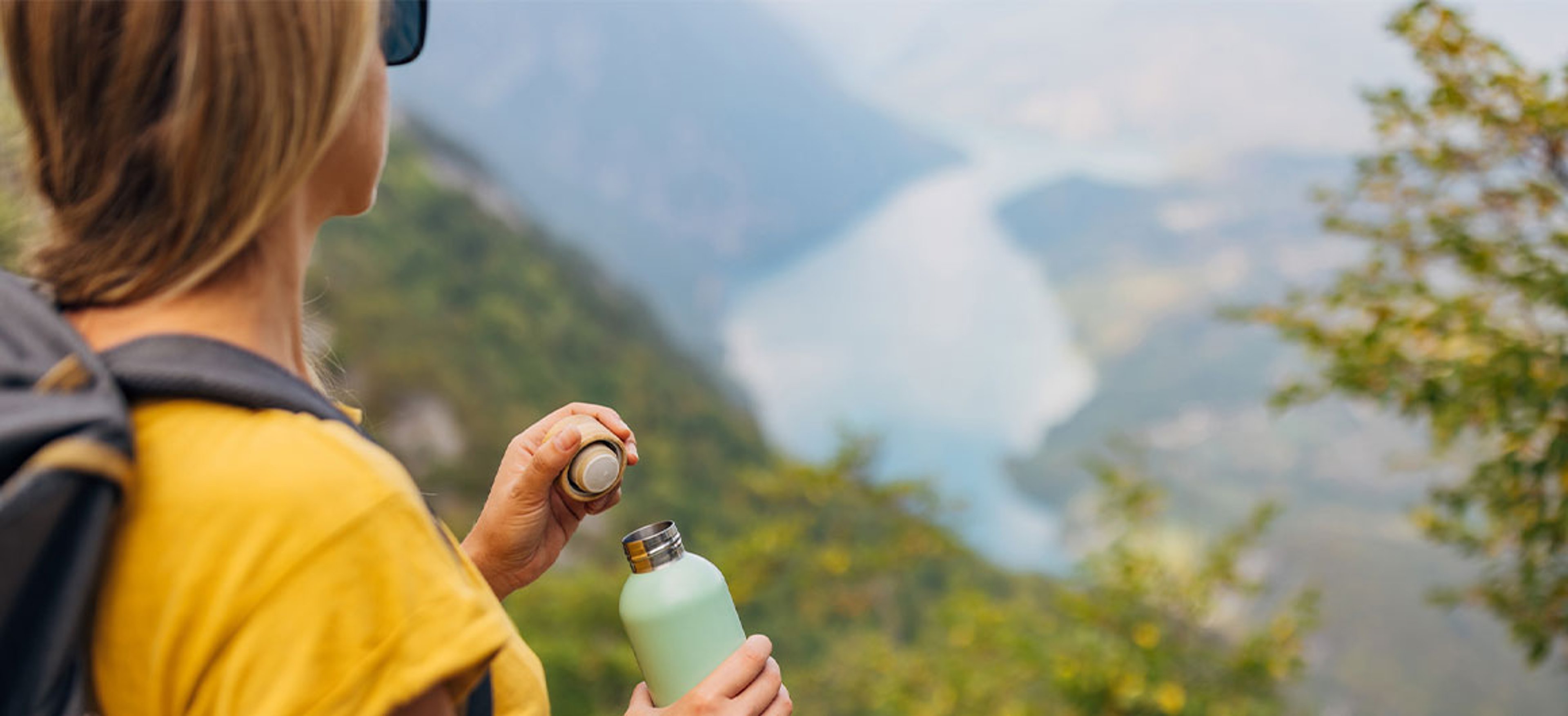 woman holding reusable water bottle and admiring view