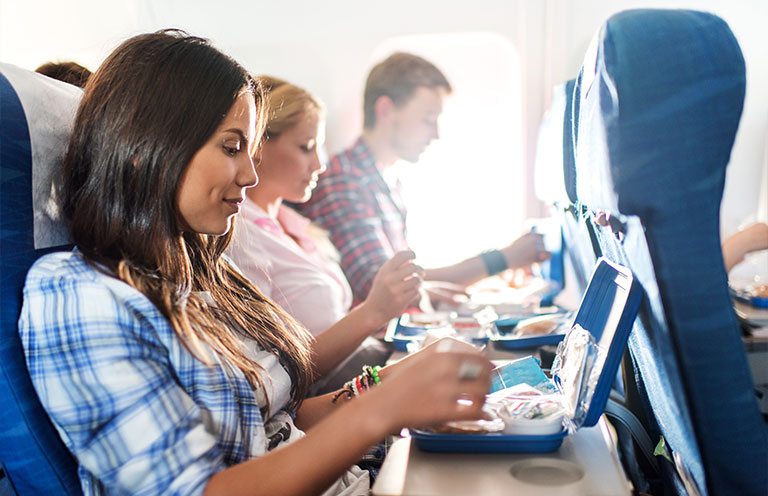 woman eating food on a plane