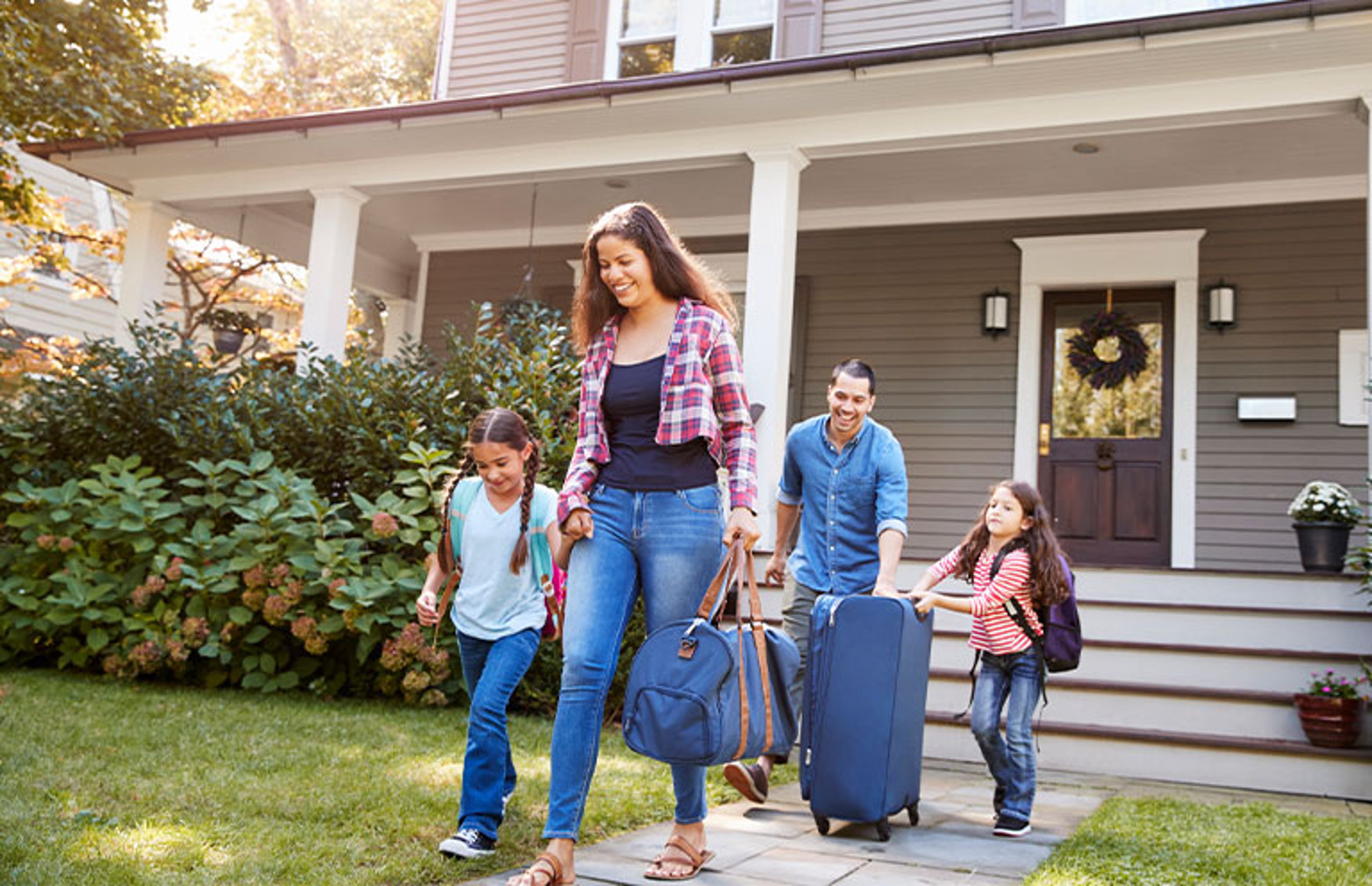 family leaving home with suitcases
