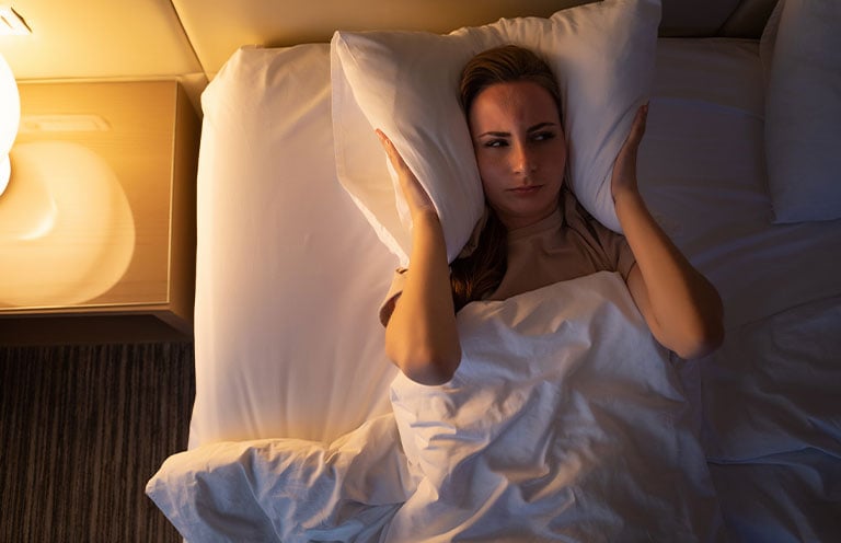 women putting pillow over head