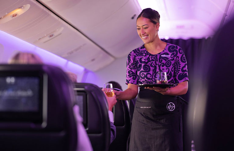 New Zealand airline flight attendant serving wine