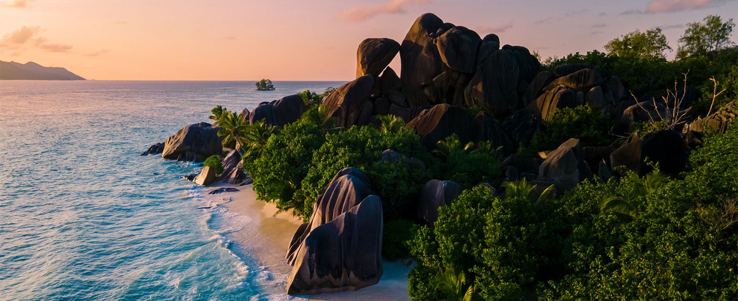 a young couple of men and women on a tropical beach during a luxury vacation in Seychelles. 