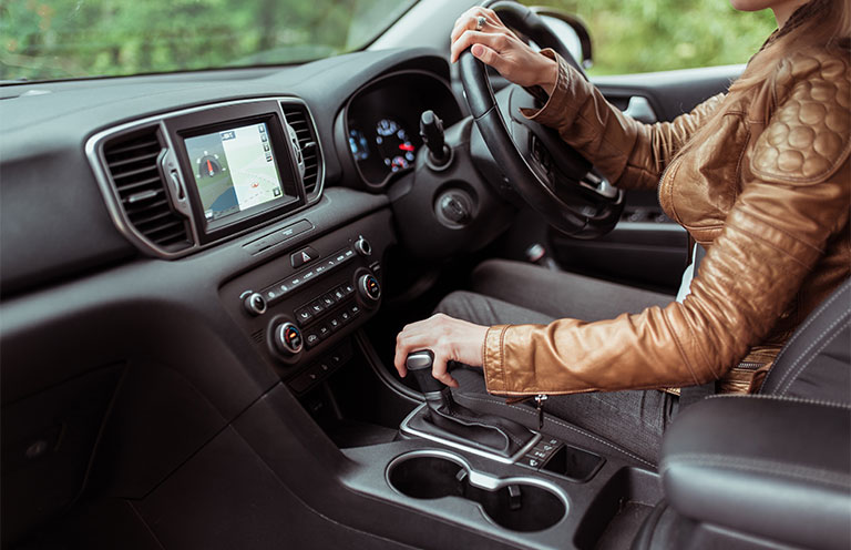 woman driving car, hand on transition gear