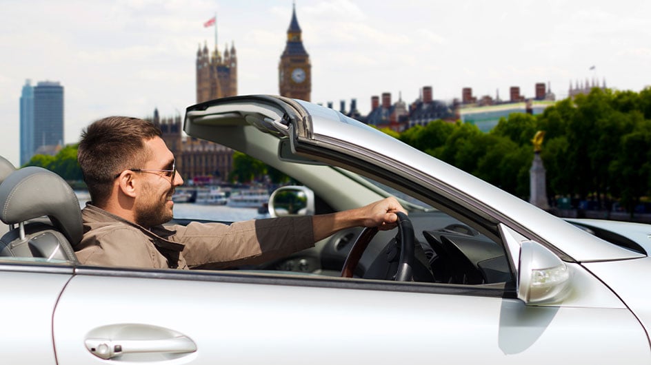 man driving car in London, Big Ben in background