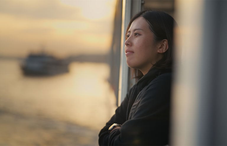 woman on ship, looking out at water