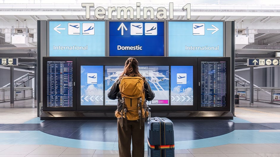 woman looking at flight schedule at airport