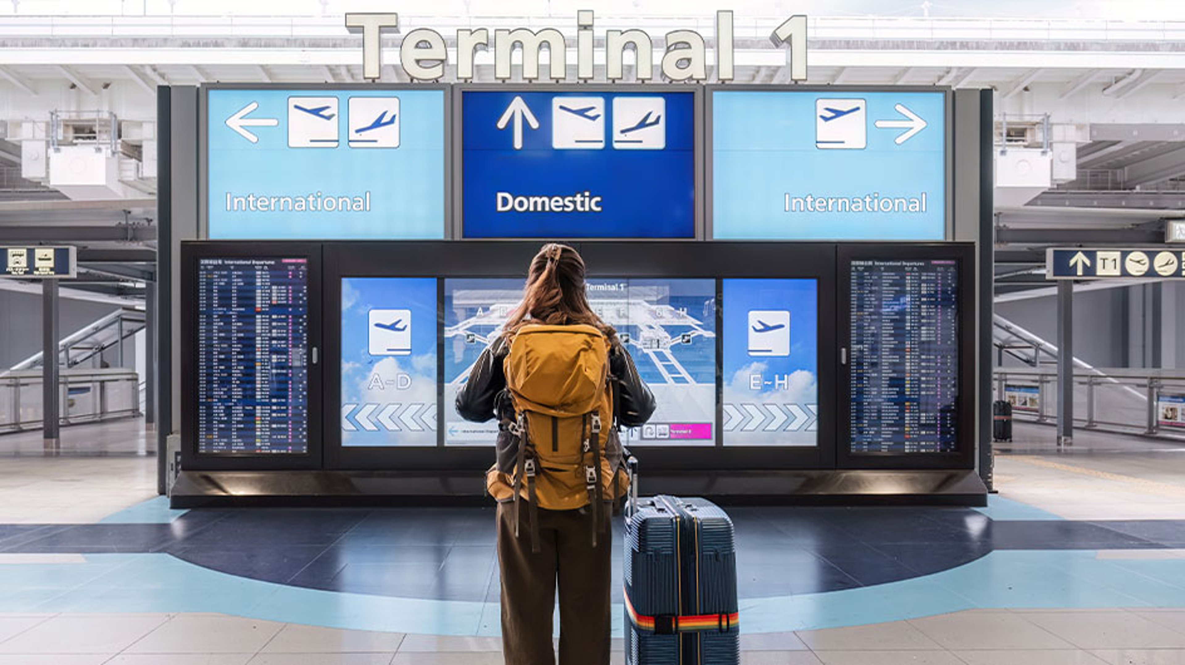 woman looking at flight schedule at airport