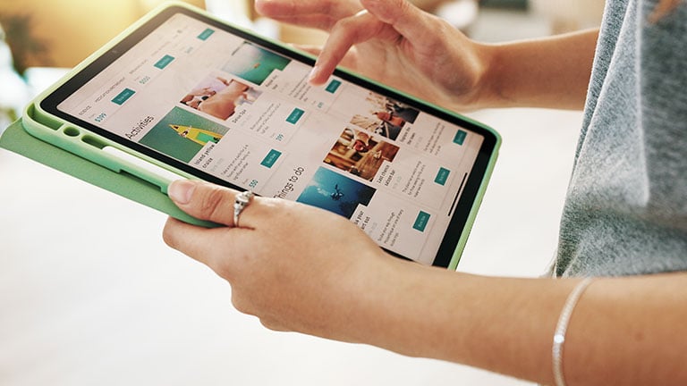 Affectionate senior lesbian couple sitting on top of hotel bed, sharing a loving moment. By Bliss