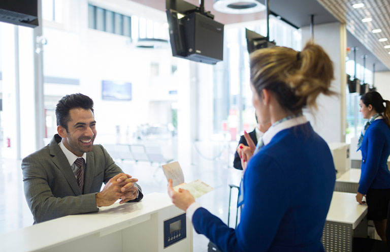 man speaking to airline worker at airport