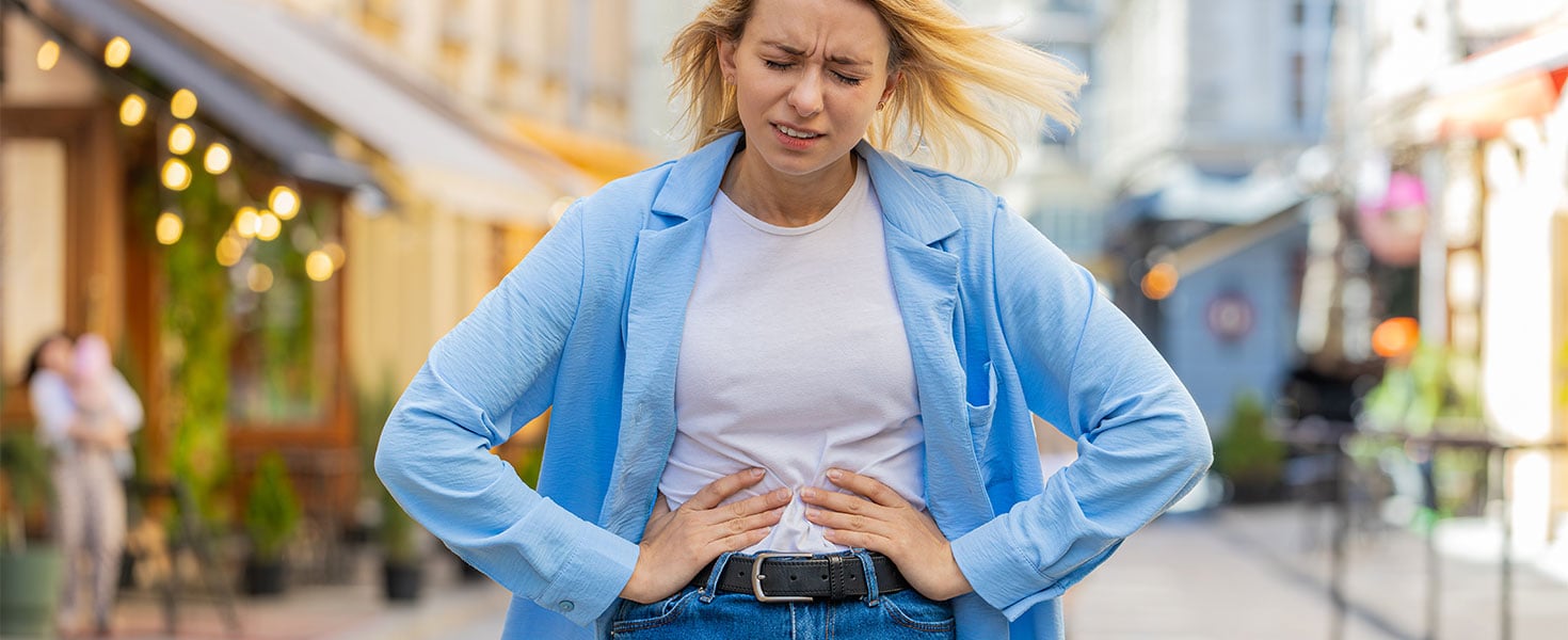 woman holding stomach uncomfortably