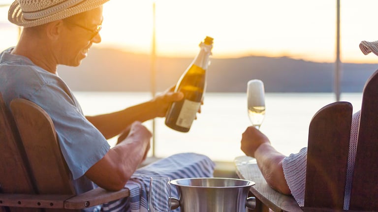 Man pouring his partner a glass of champagne at sunset. Credit:courtneyk