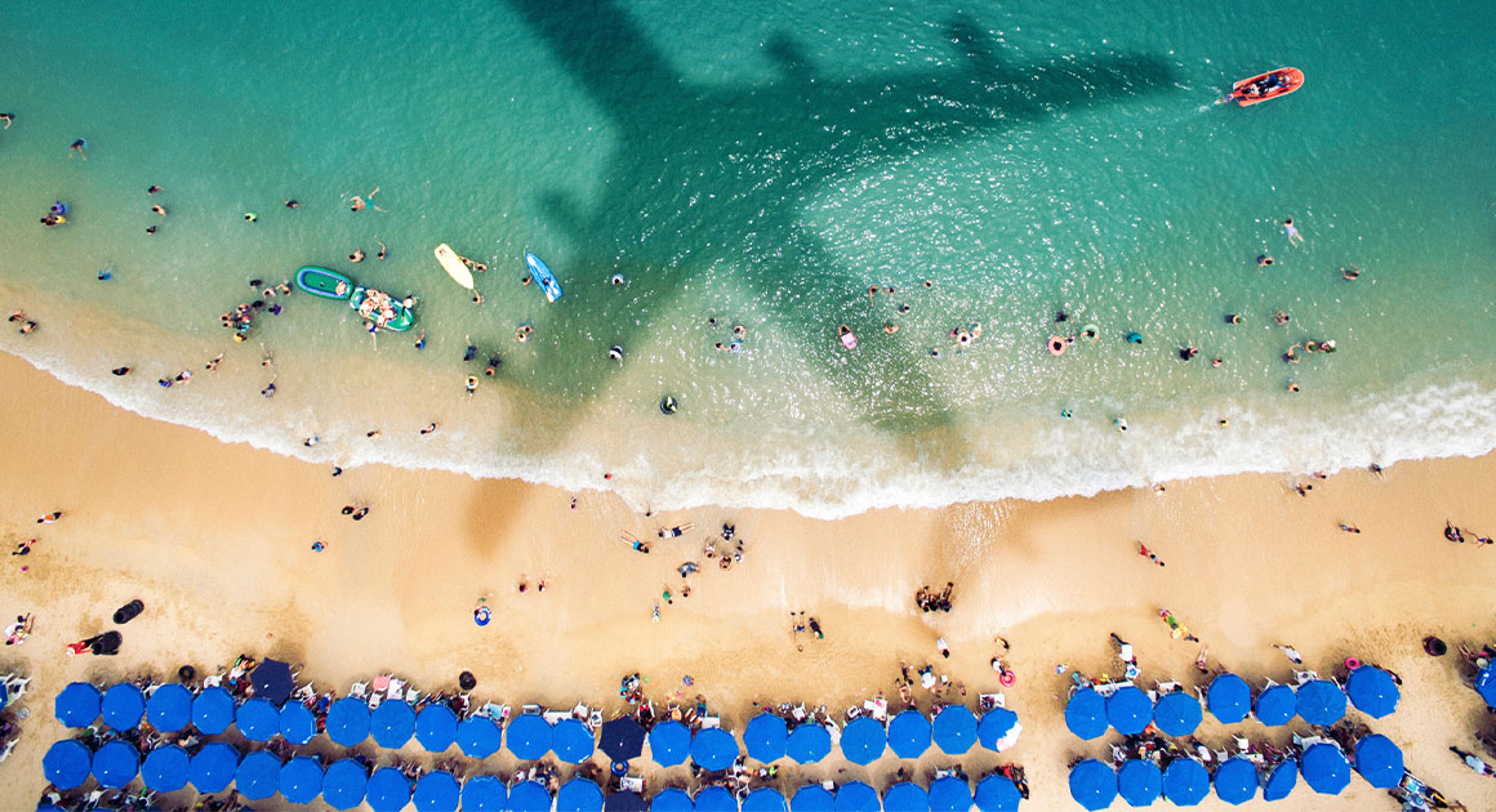 shadow of a plane flying over resort beach
