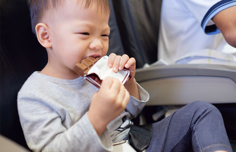 kid eating chocolate bar on airplane