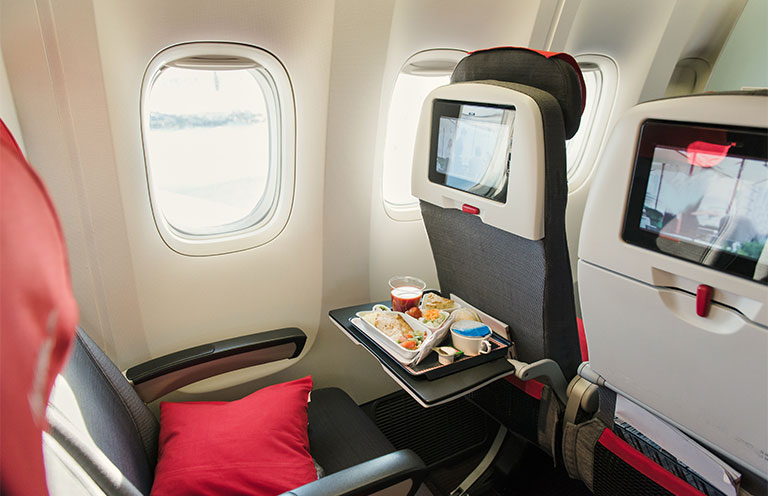 window seat on airplane with tray folded out and food on tray