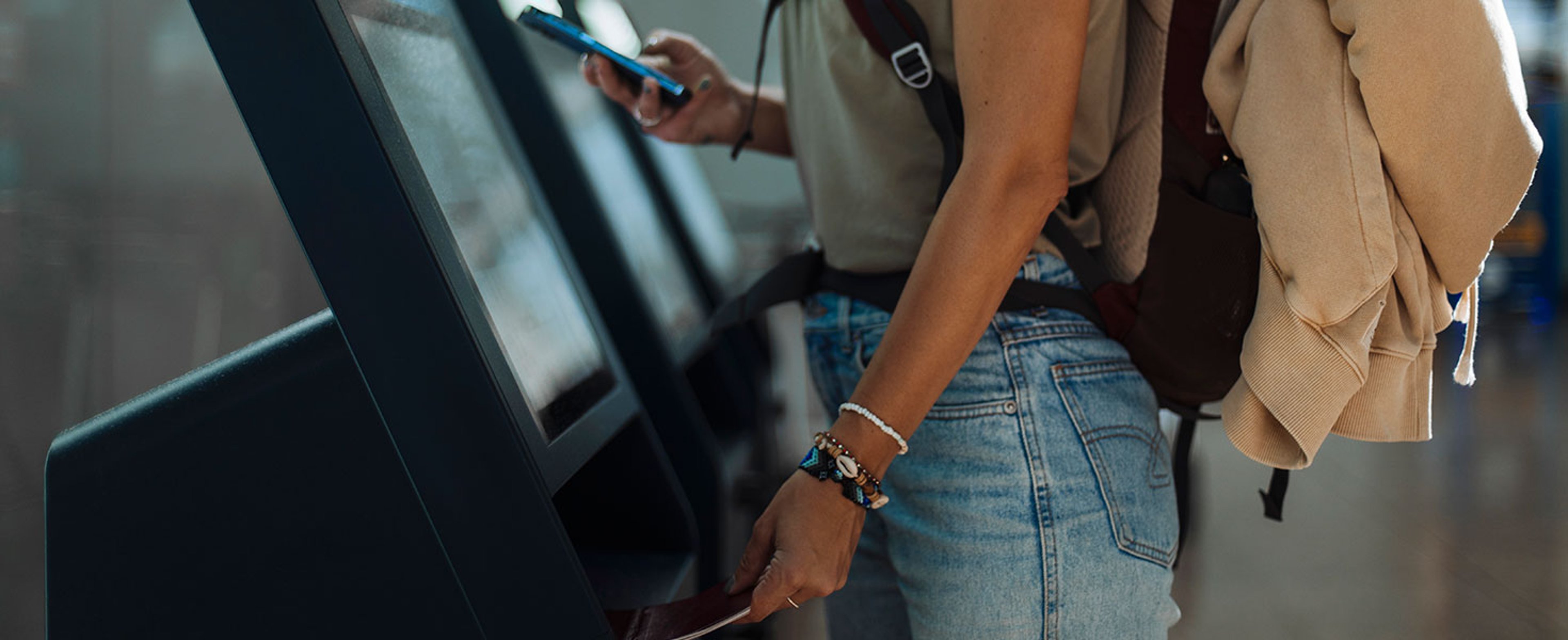 Young woman goes through self-check-in at the airport for her flight Credit: mihailomilovanovic