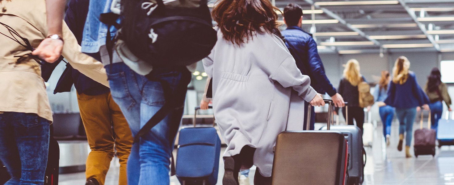 Line of people at airport hurrying with their luggage