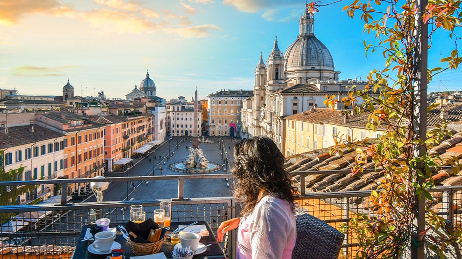 woman eating and admiring view from balcony