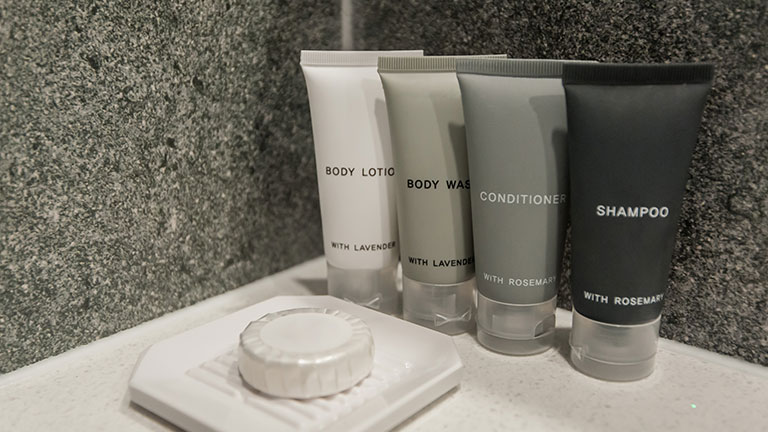toiletry bag with travel toiletries, small plastic bottles of hygiene products and soap, Hotel Guest Room Supplies