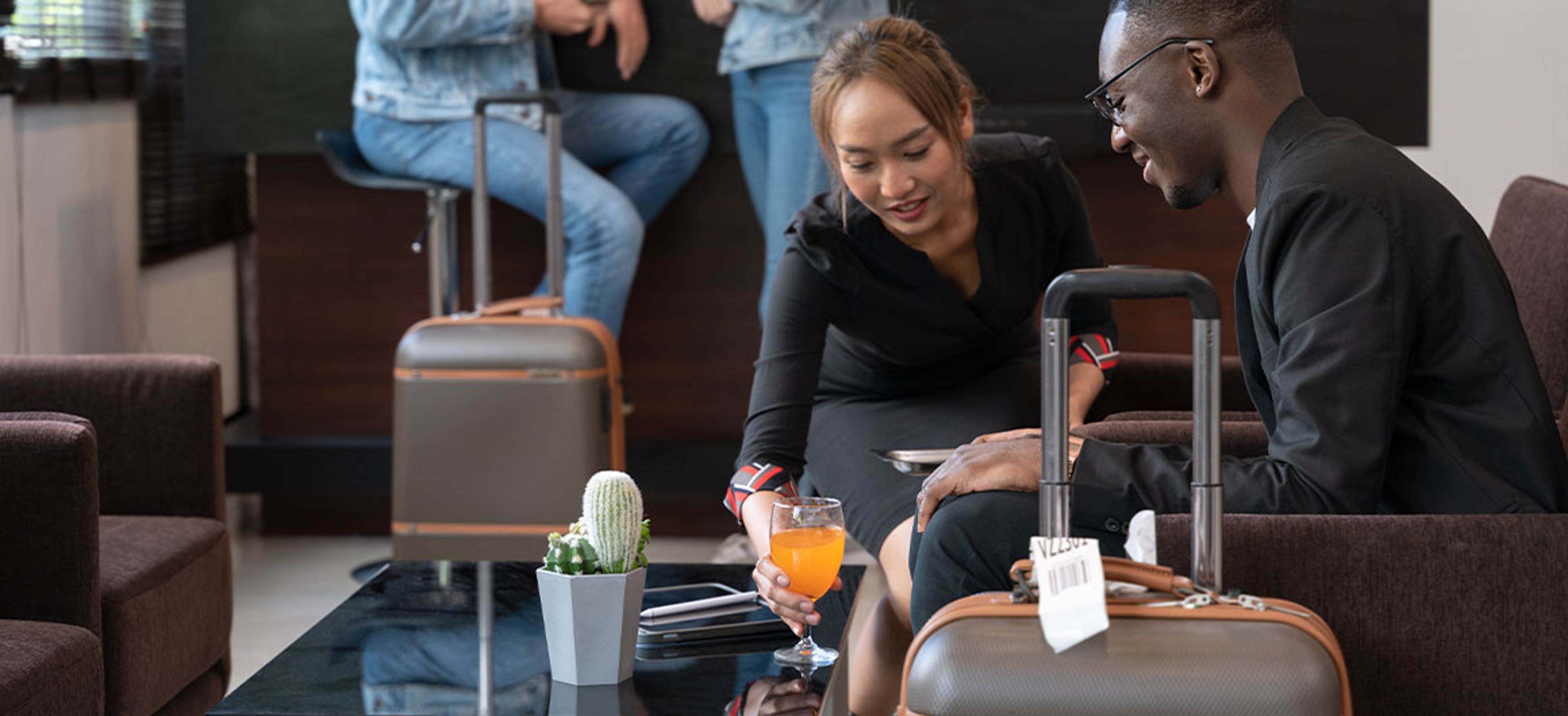 man and woman having drinks in airport lounge