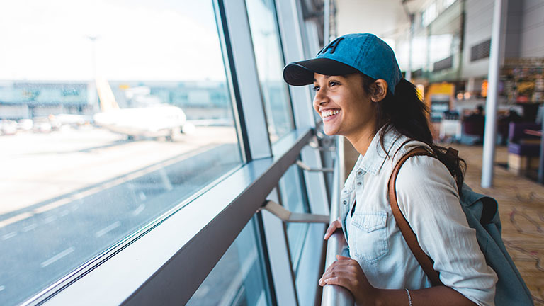 Young woman at airport waiting for airplane by Justin