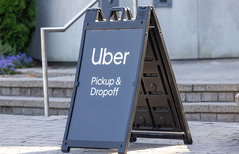black sign showing uber pick up and drop off area