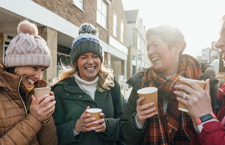 people holding coffees and laughing outside