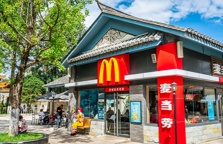 McDonalds restaurant entrance with logo and name in Chinese characters in a traditional architecture building in China