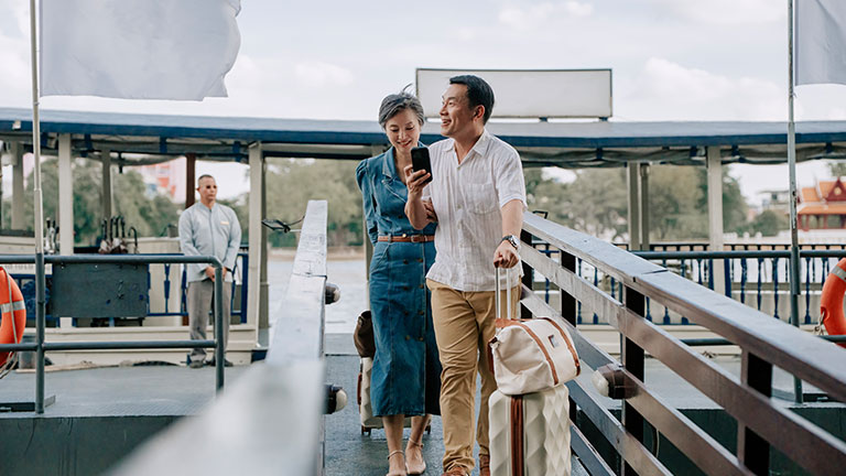 Asian Middle-Aged Man and Woman Arriving at Luxury Resort After Cruise Transfer; Credit: Edwin Tan