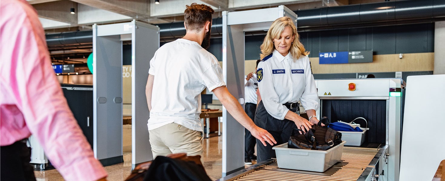 men going through airport security, tsa
