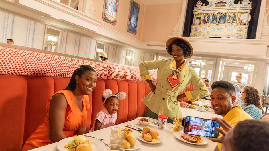 Tiana Disney character at Disney World stopping by table with a family and toddler