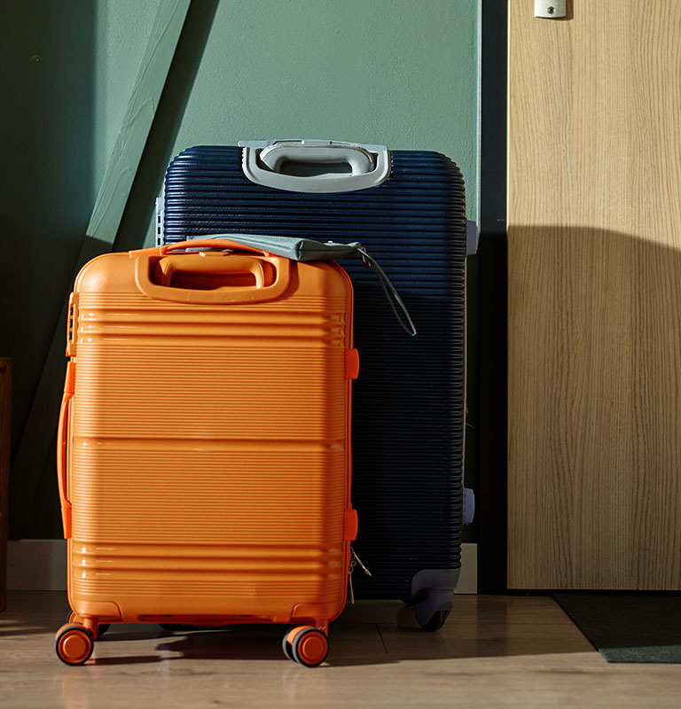 Travel suitcases near entrance door in home interior; Credit: Lazy_Bear