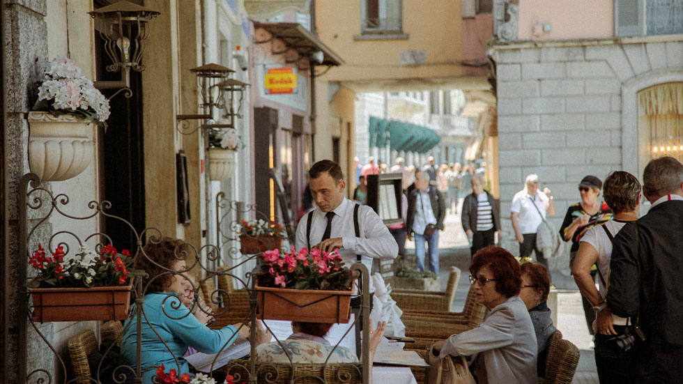 Waiter speaking to guests at Italy restaurant 