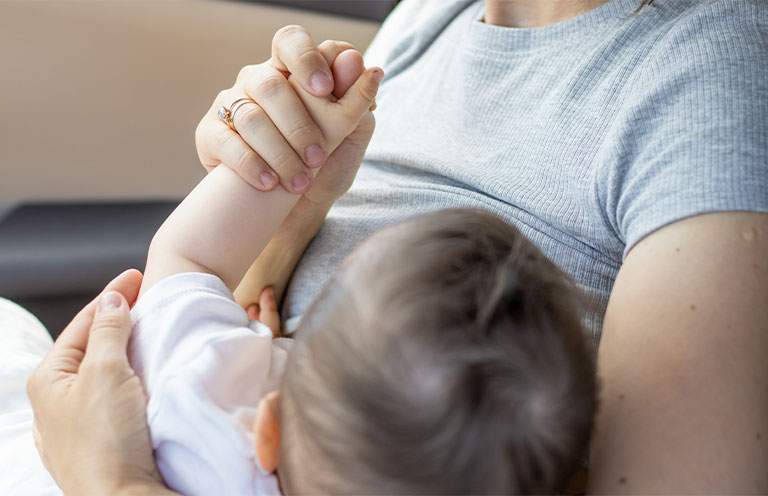 mom breastfeeding baby in car