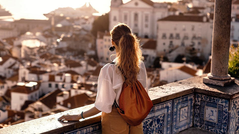 Female tourist looking at old town from balcony