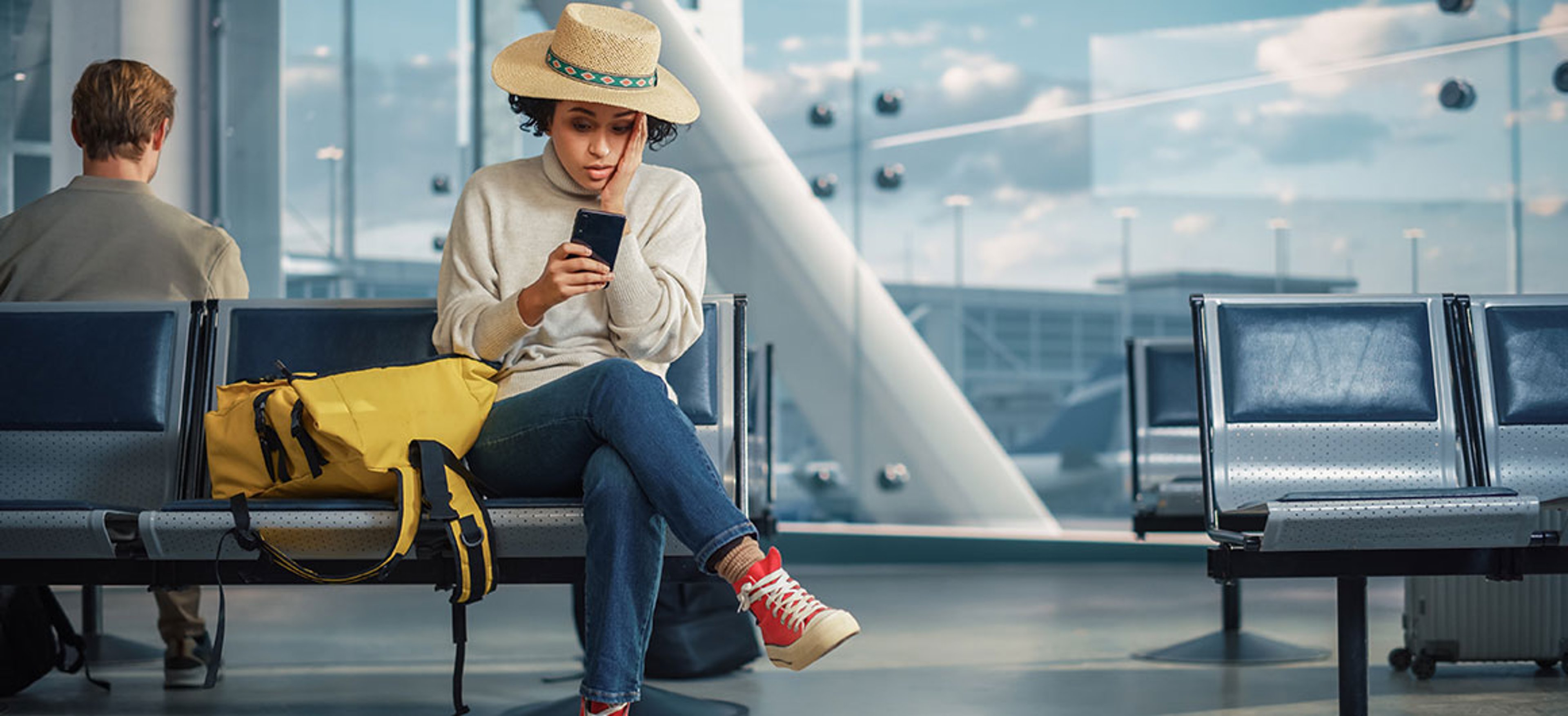 Airport Terminal: Black Woman Waits for Flight, Uses Smartphone, Receives Shockingly Bad News, Misses Flight. Upset, Sad, and Dissappointed Person Sitting in a Boarding Lounge of Airline Hub. stock photo