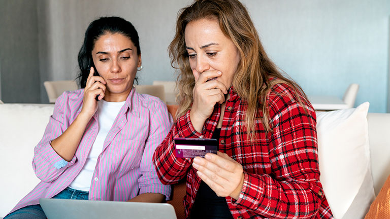 Stressed upset woman holding bank card and being surprised Credit:RainStar
