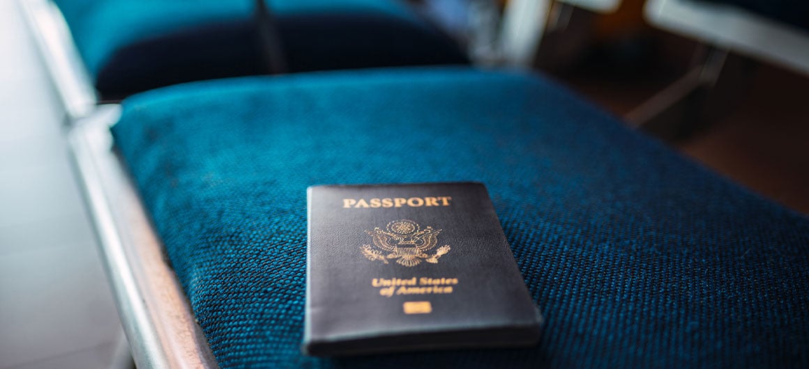 A blue American passport on a chair in an airport