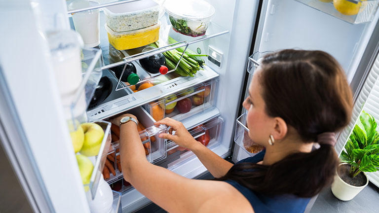 Women Looking For Food Inside Fridge In Kitchen Credit:AndreyPopov