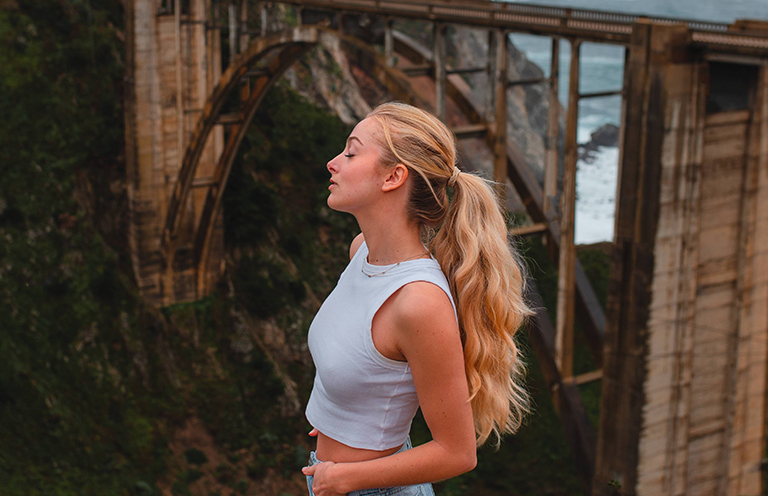 woman standing in front of big sur bridge