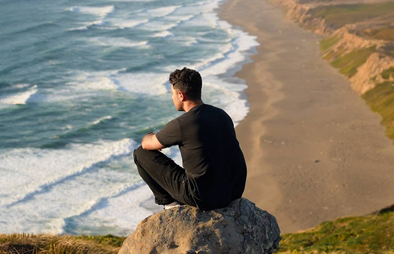 man sitting on rock, looking out at water, Point Reyes