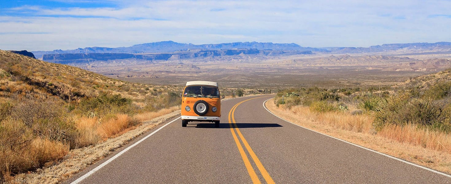 Van driving on long stretch of road