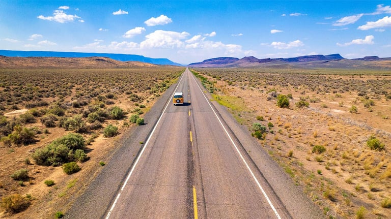 Van driving on long stretch of road