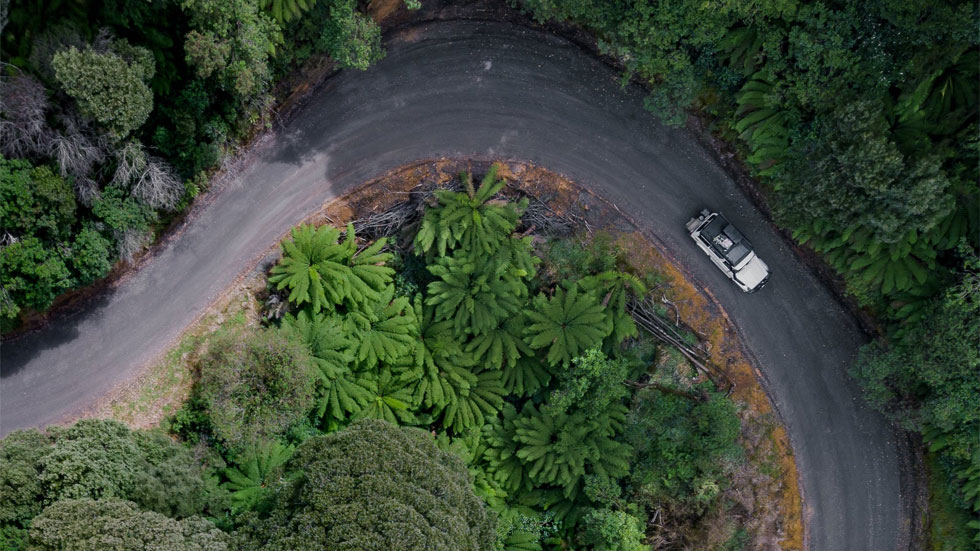 Arieal view of a car going around a sharp curve