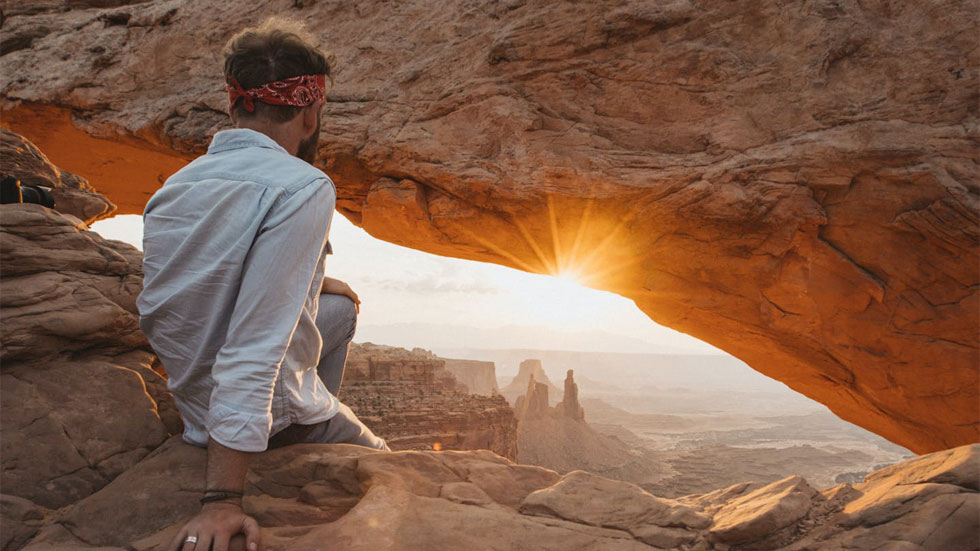 Man sitting in a National Park watching the sunset