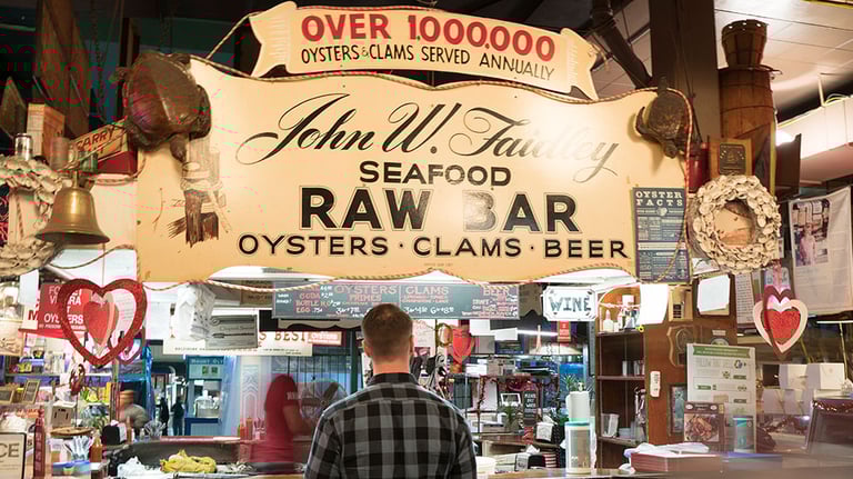 An iconic stop at Faidley’s Seafood Raw Bar in Lexington Market, serving up oysters, clams, and Baltimore tradition; Photo by John Lehr, courtesy of Visit Baltimore