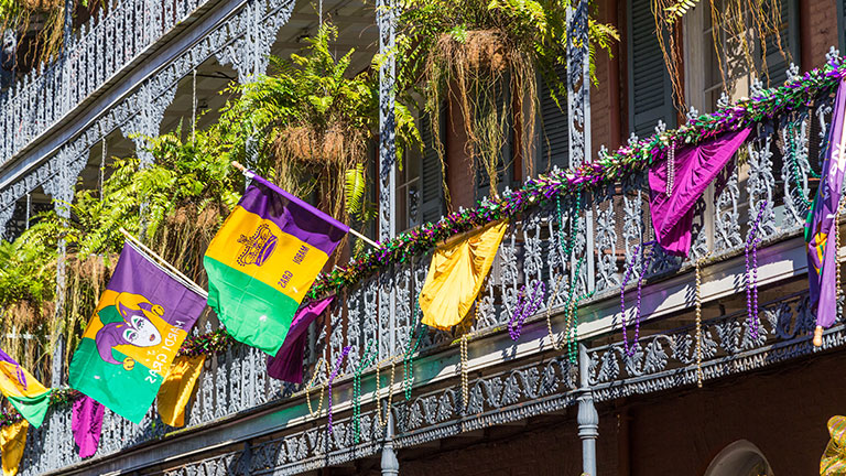Ironwork galleries on the Streets of French Quarter decorated for Mardi Gras in New Orleans, Louisiana by amadeustx