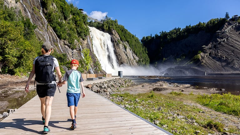 Mother and Son walking on the footbridge at Montmorency Falls in Summer, Quebec City, Canada. Credit: Onfokus