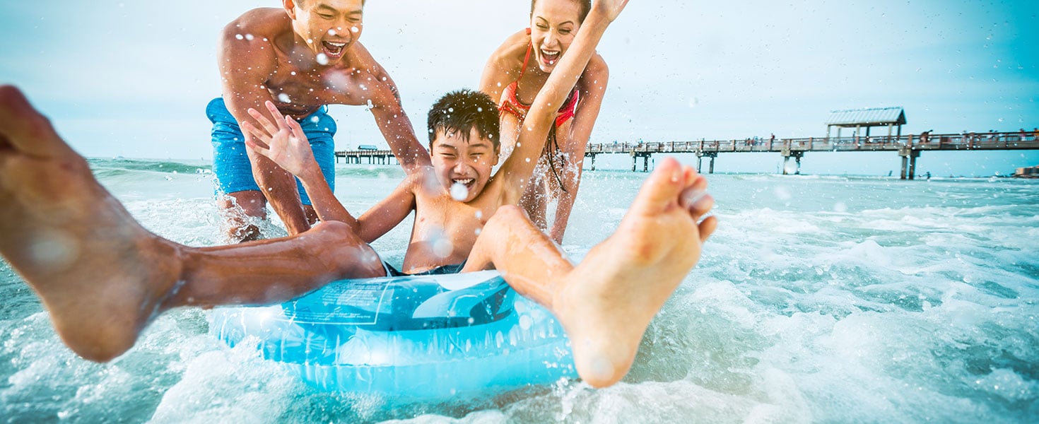 Family enjoying the waves at Clearwater Beach; photo courtesy of Visit St. Pete/Clearwater