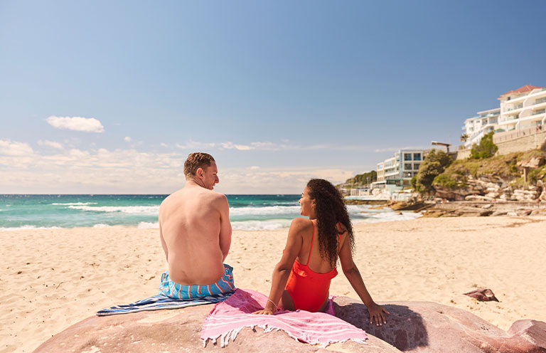 Man and woman sitting on Bondi Beach