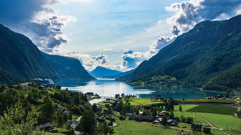 Fjord village overlooking calm blue water; photo courtesy of Adobe Stock